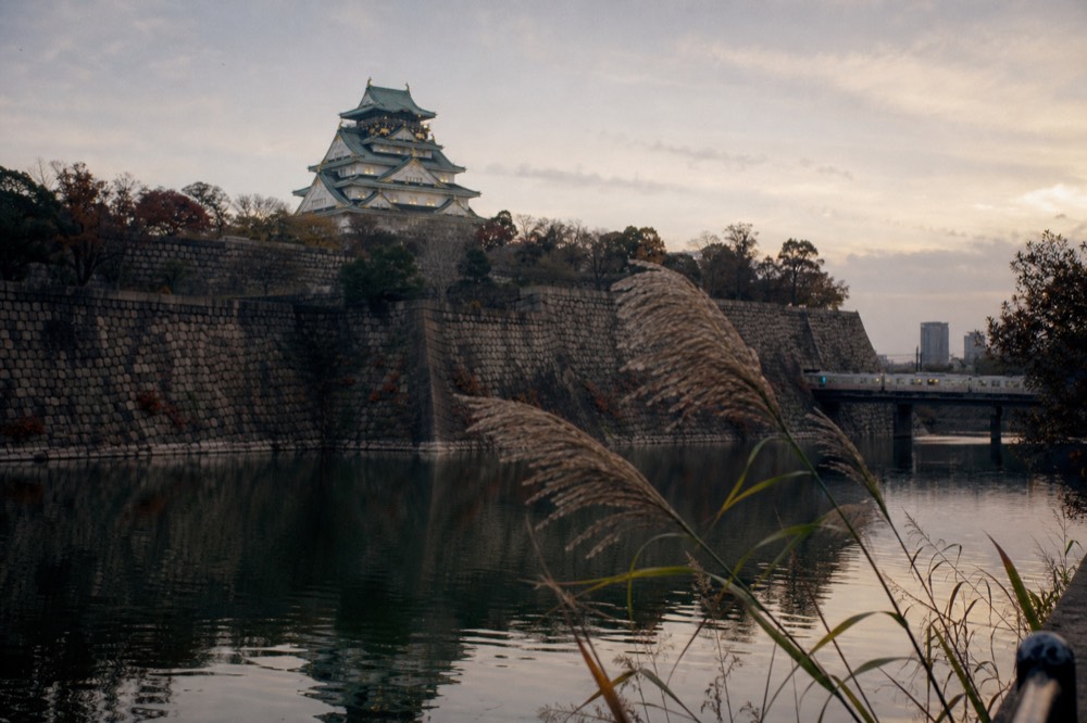 Osaka Castle keep seen across the outer moat at dusk