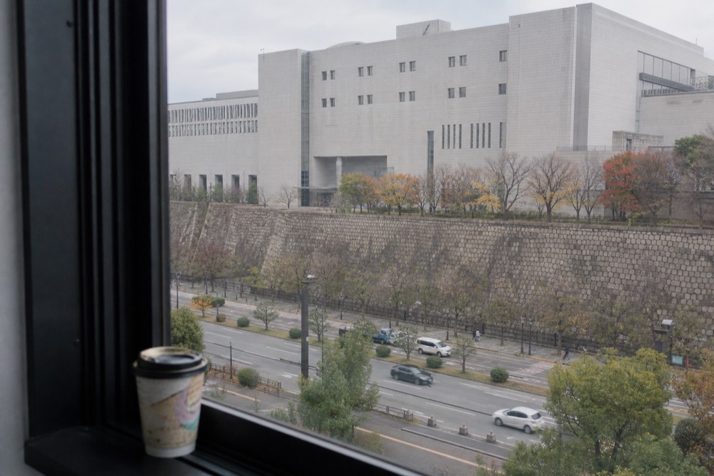 View from an upper floor toward the Osaka Museum of History building across the street from the castle park