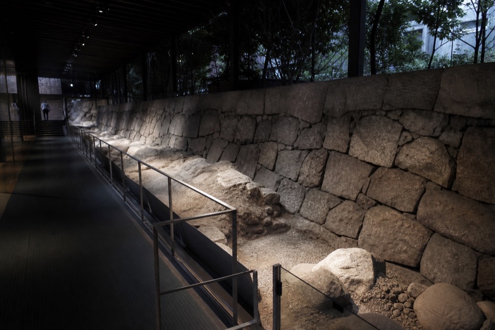 A reconstructed samurai keep rising above stone walls and a wide moat