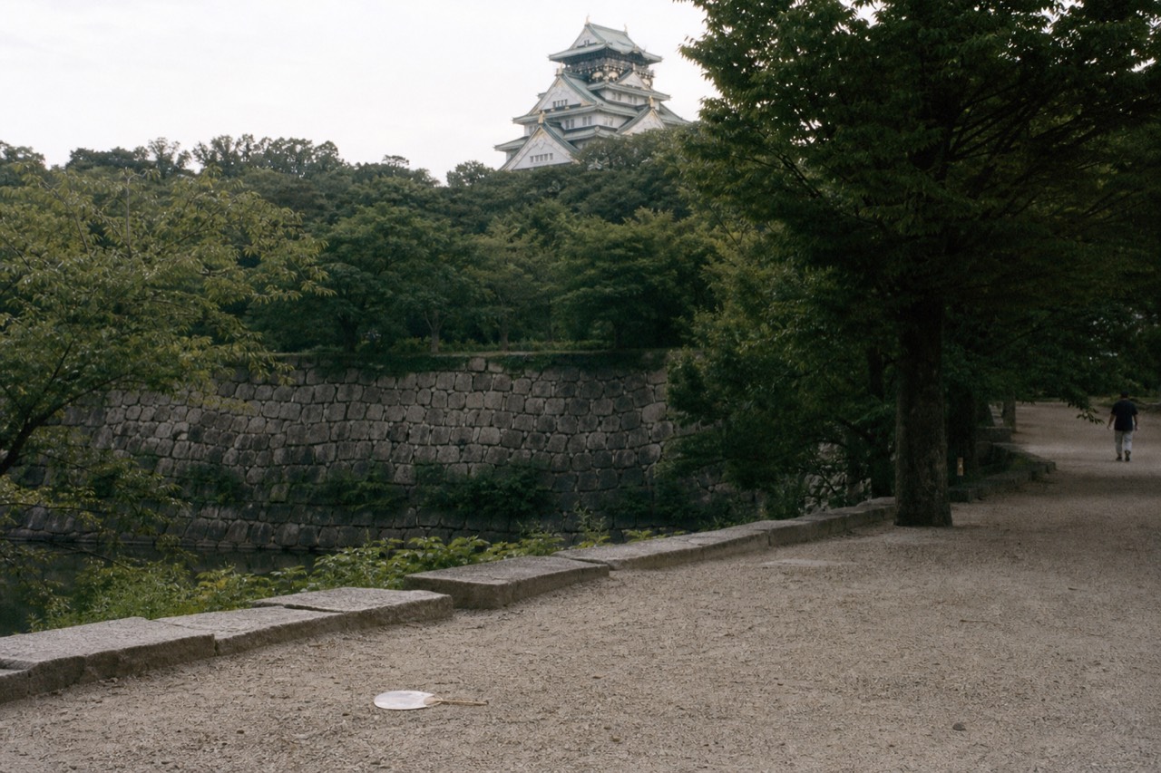 Osaka Castle tower above the park on a humid summer afternoon