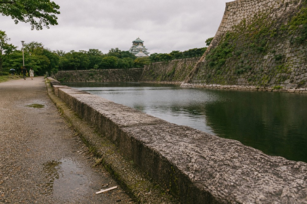 Osaka Castle moat and stone walls with the tower in the distance