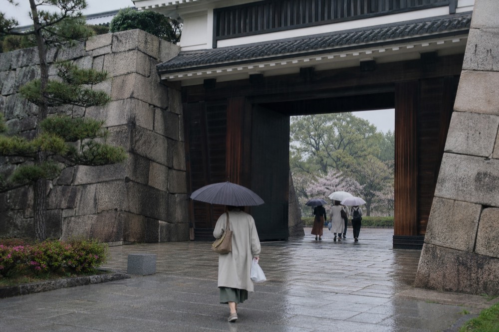 The Otemon gate of Osaka Castle, a large wooden gate set into a stone wall with visitors walking through