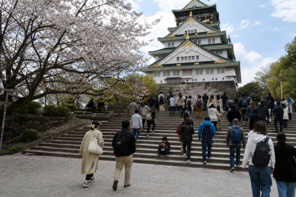 Crowds gathered on the stone steps in front of the tower entrance