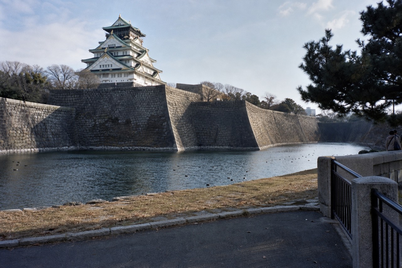 The white Main Tower of Osaka Castle rising above the moat and stone walls