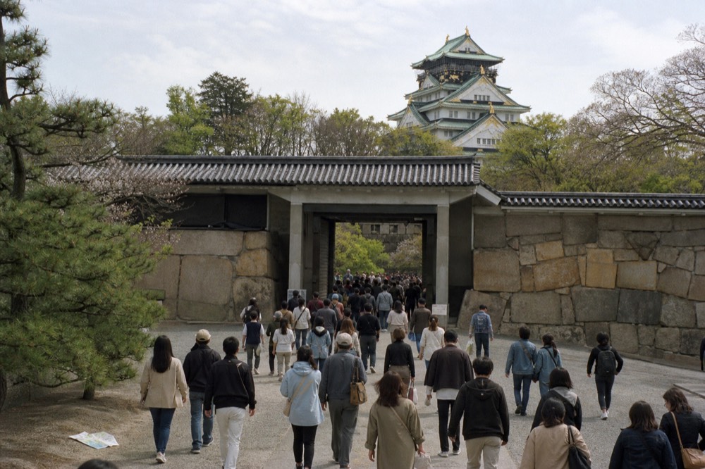 Crowds of visitors on the path leading to Osaka Castle with the tower in the distance