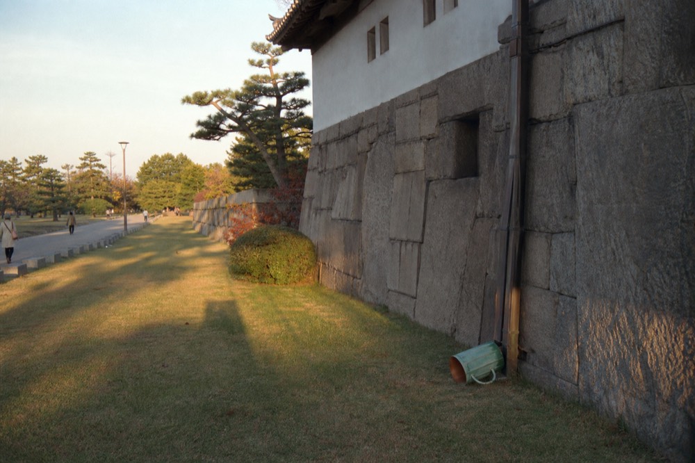 A granite building with thick stone walls beside a lawn in a castle garden