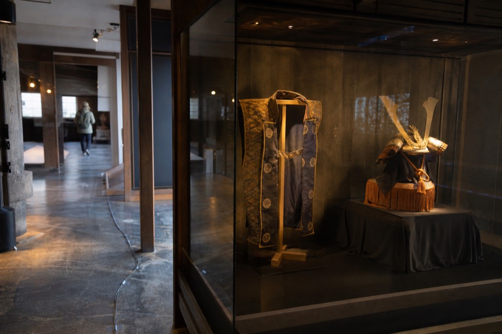 A tower interior display showing a samurai helmet and decorated surcoat