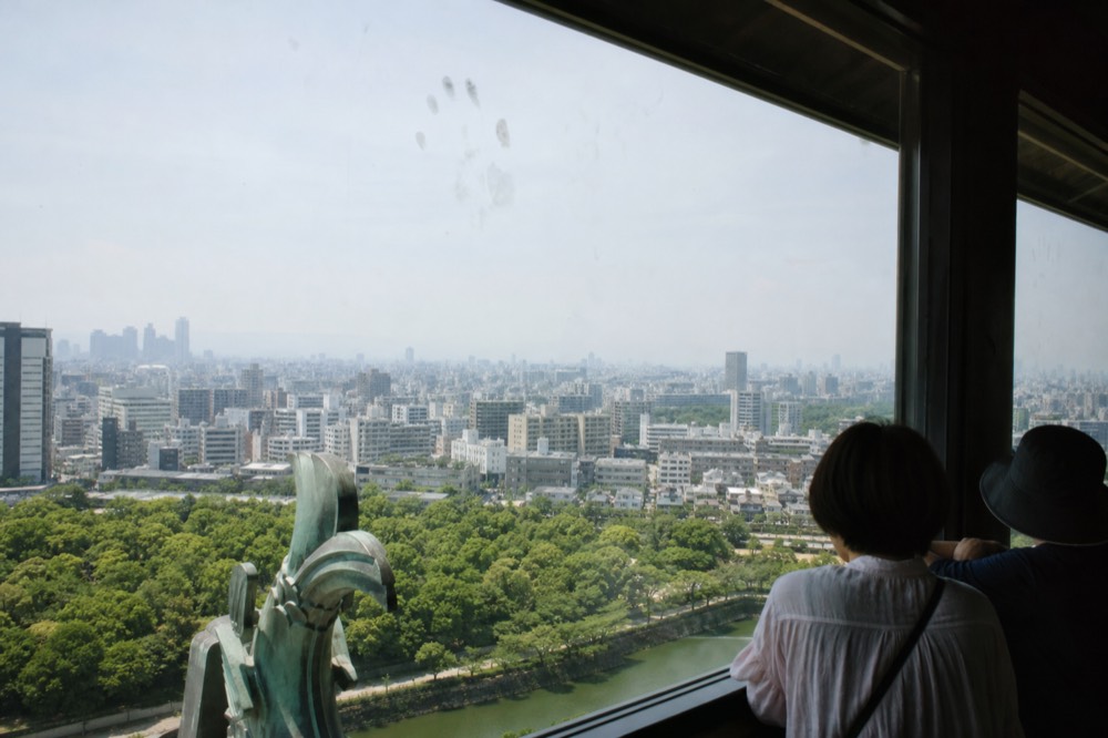 Visitors on the observation deck of Osaka Castle looking out over the city.