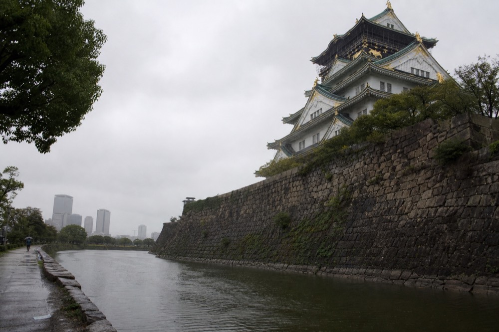 The concrete tower of Osaka Castle seen from the inner moat, with its green roof and gold ornaments