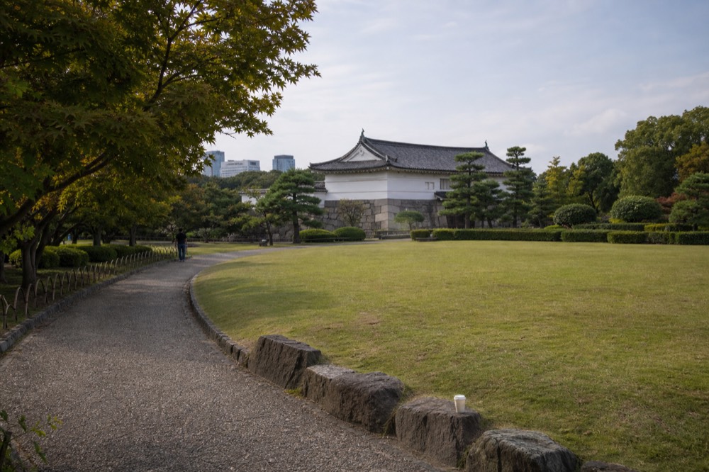 Lawn garden with a historic turret building and trees around a gravel path